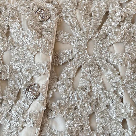 Crème Gevoerd Jasje met Opengewerkte Zilveren Details en 3D Bloemenstructuur