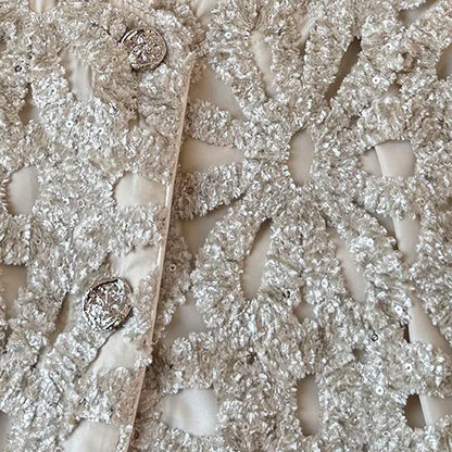 Crème Gevoerd Jasje met Opengewerkte Zilveren Details en 3D Bloemenstructuur